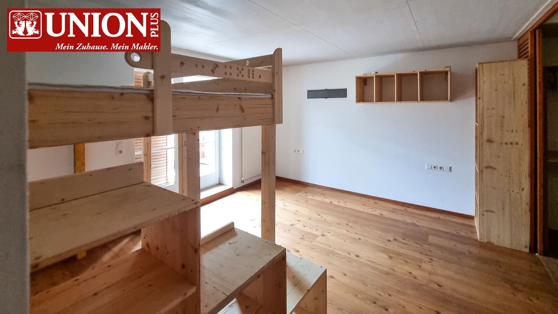Schlafzimmer mit Holzleiter und unbehandeltem Holzregal, helle Wände, Parkettboden, Balkonzugang, ideal für Immobilien- und Wohnungsanzeigen, rustikaler Stil, modernes Interior, Raumgestaltung.