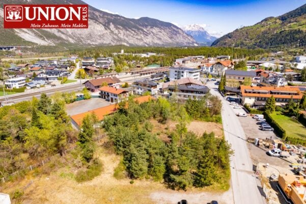 Union Plus Bergdorf inmitten beeindruckender Berglandschaft, modernes Dorf mit Wohn- und Geschäftsgebäuden, umgeben von Natur, ideal für Familien und Naturliebhaber.